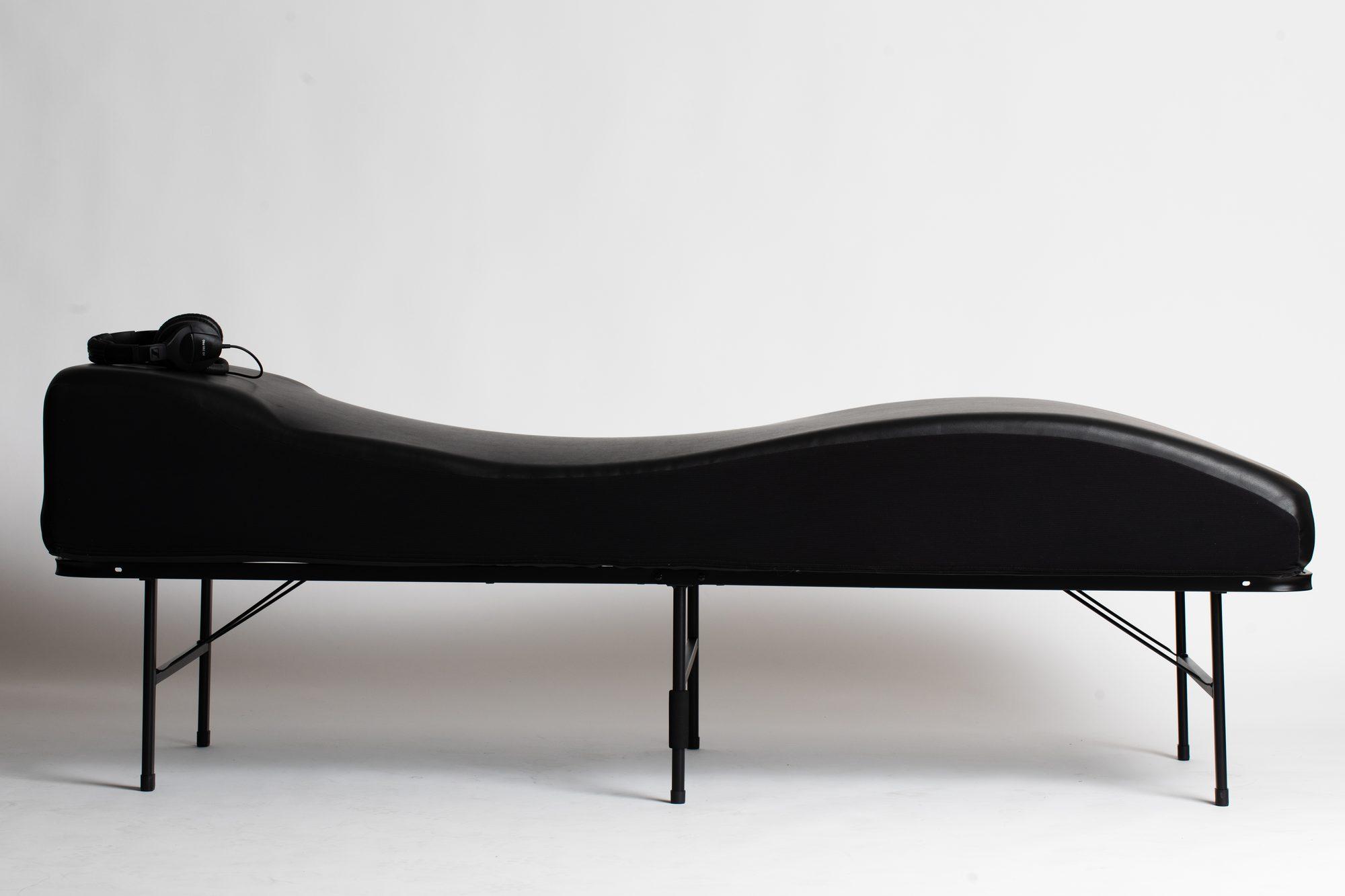 The vibroacoustic table with headphones resting at the head end